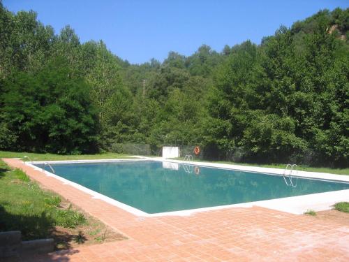 una piscina en un patio con árboles en Hostal Rural Can Enric en Sant Sadurni d'Osormort