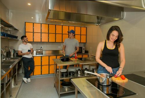 een groep mensen in een keuken die eten klaarmaakt bij Breeze Lodge in Brisbane