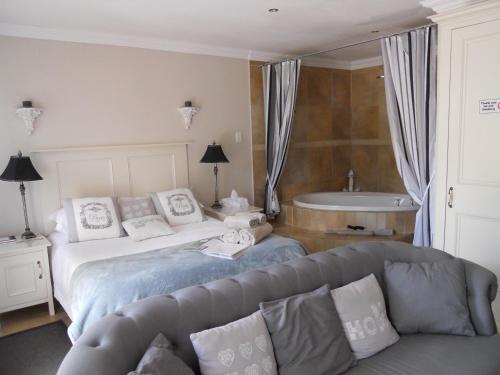 - une chambre avec un lit, un canapé et une baignoire dans l'établissement Bella Vista Self Catering, à Clarens