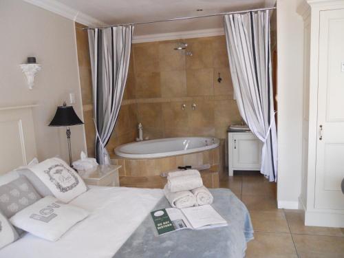 um quarto com uma cama e uma banheira em Bella Vista Self Catering em Clarens