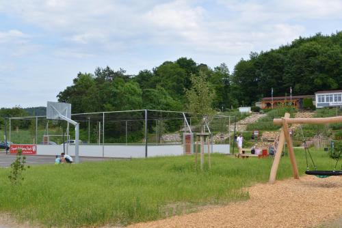 um parque com um cesto de basquetebol e um parque infantil em Campinghütte im SportErlebnisPark Allmersbach im Tal em Allmersbach im Tal
