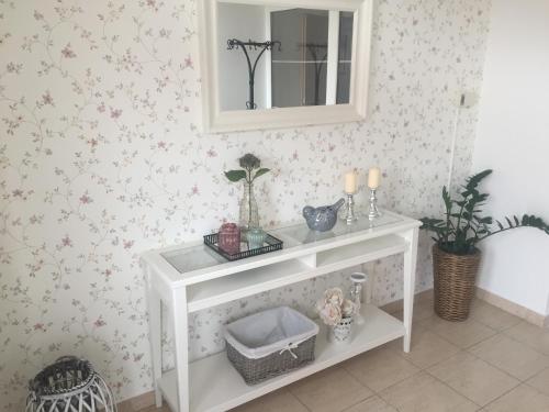 Una consola blanca en una habitación con flores en Evička Penzion, en Veľký Meder