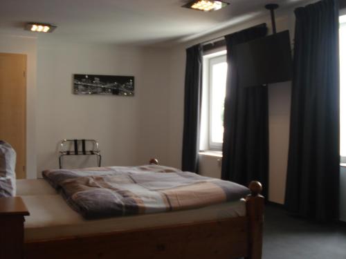 een slaapkamer met een bed en een raam bij Hotel Restaurant Fritz in Gronau