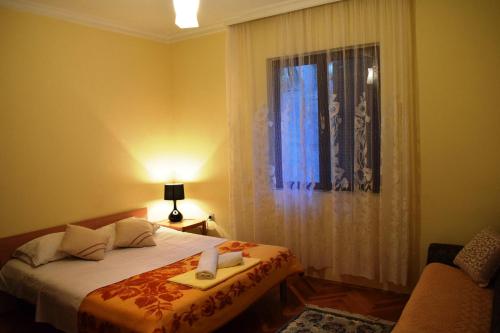 a bedroom with a bed and a window and a chair at Bisha Apartments in Ulcinj