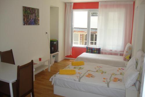Una pequeña habitación con dos camas y una ventana. en Guest Rooms Colours, en Kazanlak