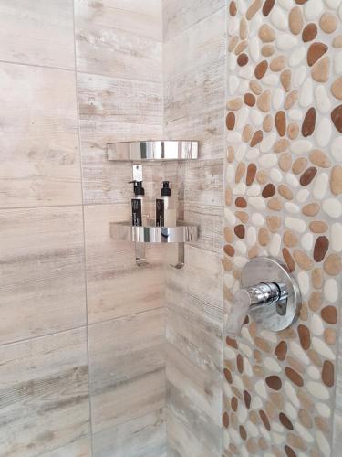 a bathroom with a shower with a stone wall at 178 Club in Pretoria