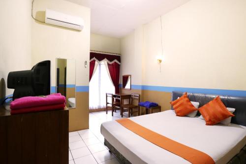 Un pat sau paturi într-o cameră la Hotel Wisata