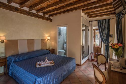 a bedroom with a blue bed with a tray on it at Relais Le Clarisse in Rome