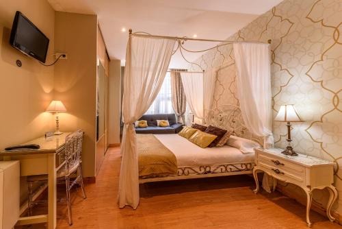 a bedroom with a canopy bed and a window at Hosteria Villa de Castro in Castro-Urdiales
