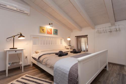 sypialnia z dużym białym łóżkiem w pokoju w obiekcie Apartments and Rooms Hey Rovinj w Rovinj