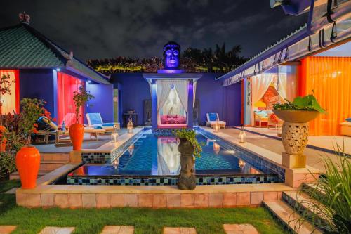 a house with a swimming pool at night at Villa Majorelle Bali in Seminyak