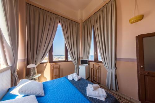 a bedroom with a blue bed with towels on it at Palazzo Vallebona in Gallipoli