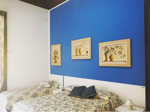 1 dormitorio con 2 camas y pared azul en B&B Albatros, en Lipari