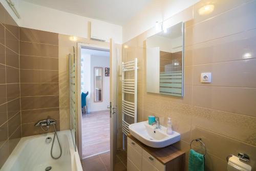 a bathroom with a sink and a bath tub at Blue Lake Appartman in Siófok