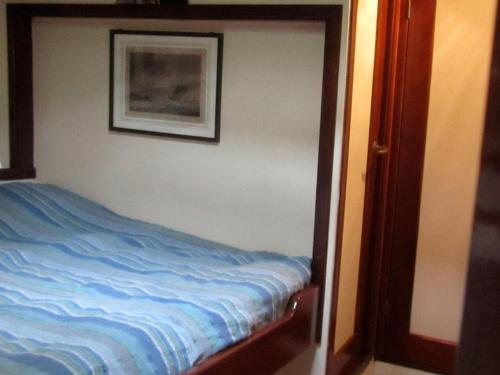 uma cama num quarto com uma fotografia na parede em Zeilschip Fortuna em Medemblik