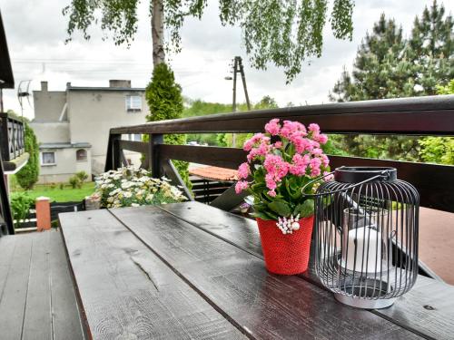 a vase of pink flowers sitting on a wooden table at Gościniec Pod Markizami in Malbork