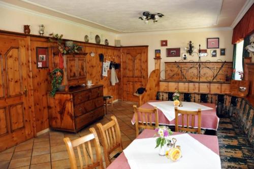 a dining room with two tables and wooden walls at Gasthof Kirchenwirt in Zederhaus