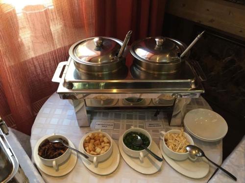 a buffet with two pots and bowls of food at Springs Hotel Ulaanbaatar in Ulaanbaatar