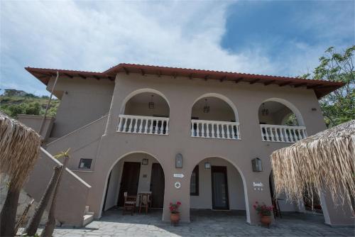 een groot huis met bogen en een patio bij The Beach House - Apartments & Studios in Afitos