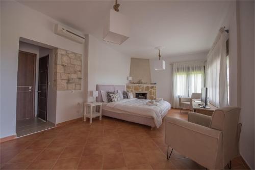 - une chambre avec un lit, un canapé et une télévision dans l'établissement The Beach House - Apartments & Studios, à Afytos
