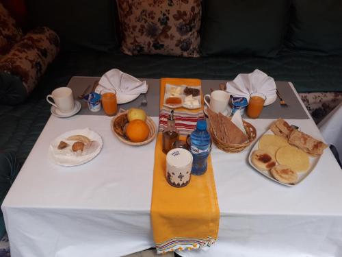 una mesa blanca con desayuno y bebidas. en Dar Meziana, en Chefchaouen