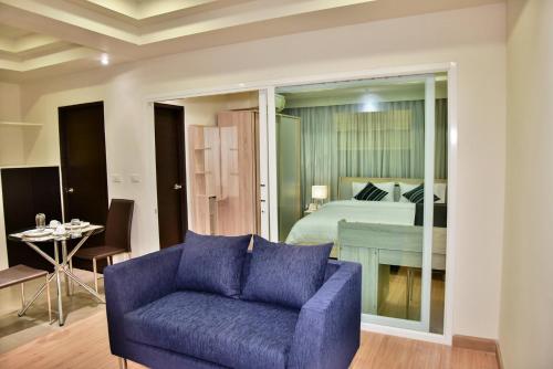 a living room with a purple couch and a bed at The Kaze 34 Hotel and Serviced Residence in Bangkok