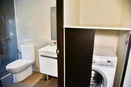 a small bathroom with a washing machine and a washer at The Kaze 34 Hotel and Serviced Residence in Bangkok
