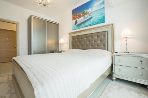 ママイアにあるApartament Ultra Luxの白いベッドと壁に絵画が飾られたベッドルーム1室