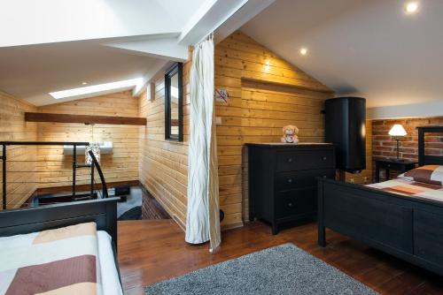 1 dormitorio con paredes de madera, 1 cama y escritorio en Apartment Greg, en Cracovia