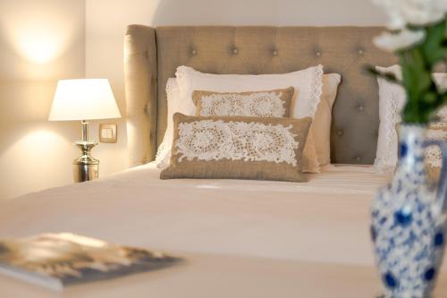 a bedroom with a white bed with a vase of flowers at Heritage suites Zanini in Hvar