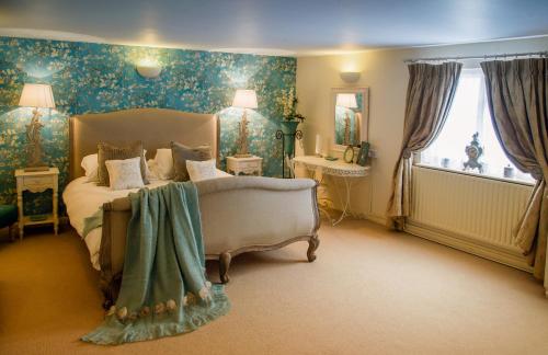 a bedroom with a bed and a large window at The Queens Head in Belton