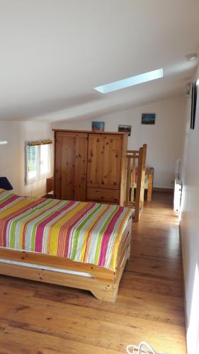 1 dormitorio con 1 cama en una habitación con suelo de madera en Le Pas des Lanciers en Mallemort