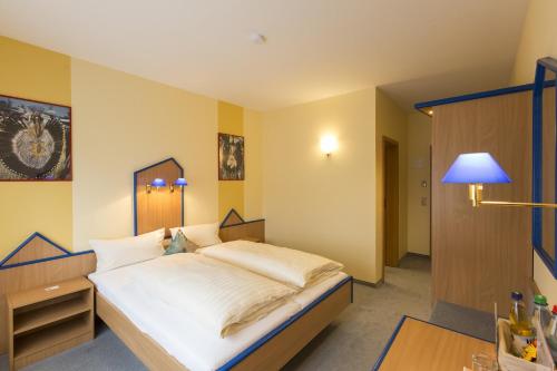 1 dormitorio con 1 cama grande con sábanas blancas en Globotel Business, en Garbsen