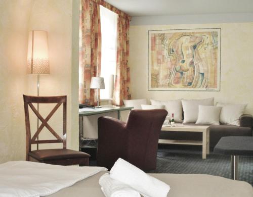 a hotel room with a couch and a table at Hotel Ostseestern in Kühlungsborn