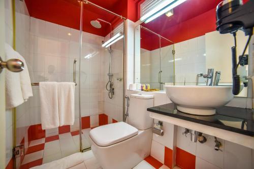 a bathroom with a white toilet and a sink at Coral Rock by Bansei in Hikkaduwa