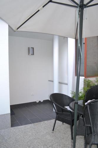 uma mesa e cadeiras com um guarda-sol num quarto em Apartment Šik 1 em Koper