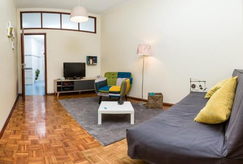 a living room with a couch and a chair at Downtown Shelter - Casa da Praça in Aveiro