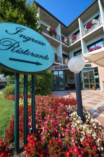 a sign in a flower bed in front of a building at Hotel Eden in Valeggio sul Mincio