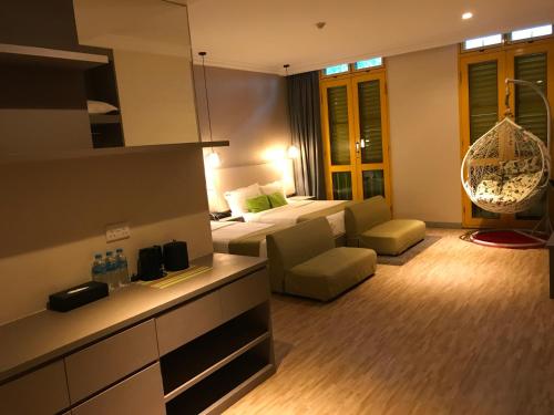 Habitación de hotel con cama y sala de estar. en Champion Hotel en Singapur