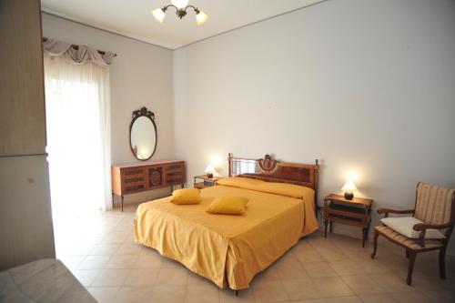 a bedroom with a bed with yellow sheets and a mirror at Palazzo Mascolo gruppo mascololuxuryapartments in Agerola