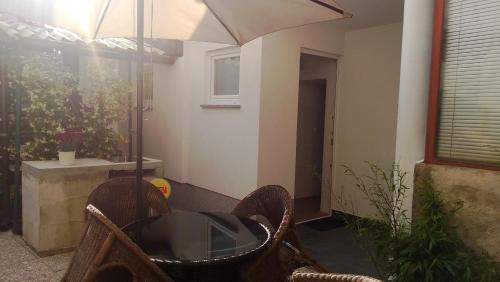 een patio met een tafel en een parasol bij Apartment Šik 1 in Koper