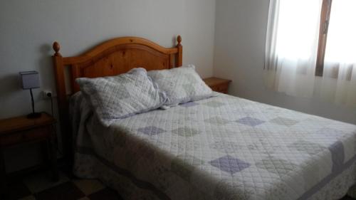 a bedroom with a bed with a quilt on it at Las Belisas in Arenal d'en Castell