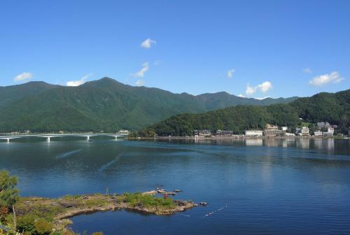 a large body of water with mountains in the background at Kasuitei Ooya in Fujikawaguchiko