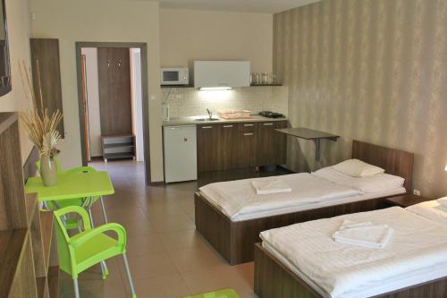 a hotel room with two beds and a kitchen at Toskána in Veľký Meder