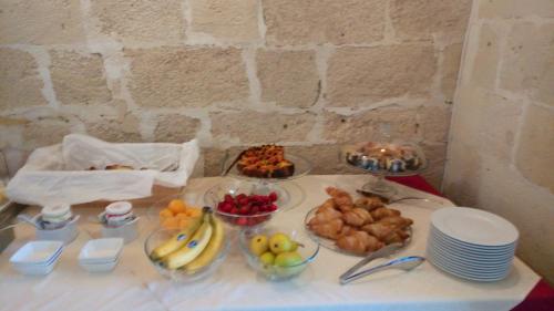 a table with bowls of fruit and plates of food at Le Dimore Dell' Idris in Matera