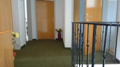 a hallway with doors and a stairway with a stair railing at Haus Alpina in Weissensee