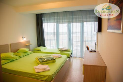 Ένα ή περισσότερα κρεβάτια σε δωμάτιο στο Vila Evergreen 2 Mai