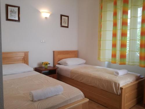 two twin beds in a room with a window at Villa Ruzica in Trogir