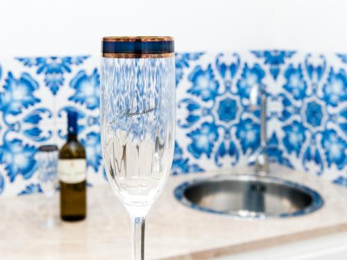 a wine glass with a bottle of wine next to a sink at White in Castellammare del Golfo