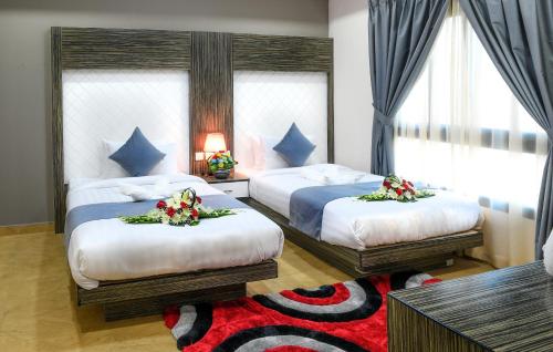 ein Schlafzimmer mit 2 Betten mit Blumen drauf in der Unterkunft Montana Tower in Manama